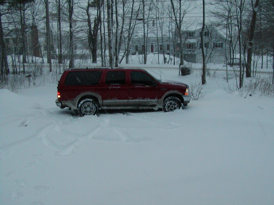 Red 2002 Ford Excursion in snow