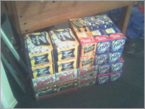 1993 Ford Bronco - Multiple cases of beer are stacked on a floor, partially obscured by wooden furniture.