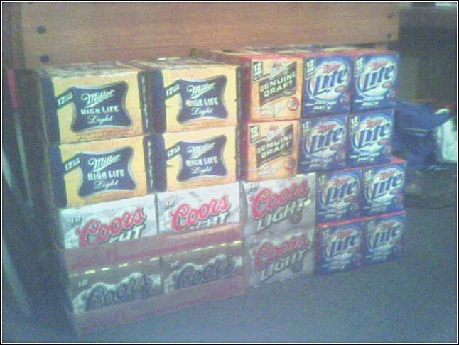 Cases of Miller High Life, Coors Light, and Genuine Draft beer stacked