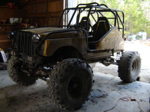 1989 Ford Bronco - This heavily modified off-road vehicle features a prominent roll cage and oversized tires, suggesting it is built for extreme terrain.