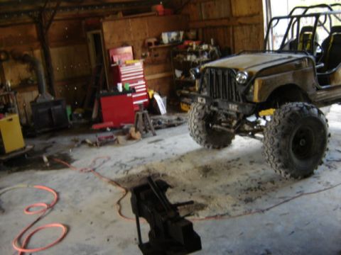 1989 Ford Bronco - This modified off-road vehicle is parked inside a garage with tools and equipment visible.