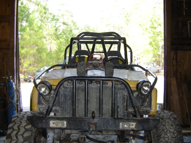 Yellow off-road vehicle front view with roll cage and large tires