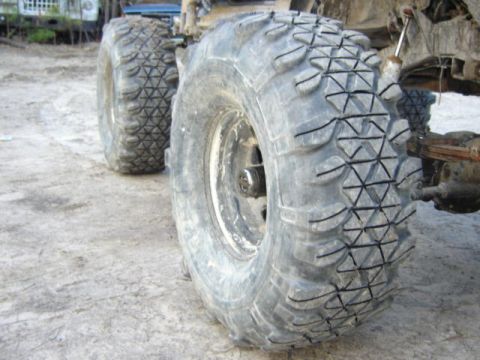 1989 Ford Bronco - Close-up view of the tires and suspension of an off-road vehicle.