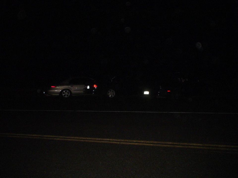 Side view of two cars at night on a road