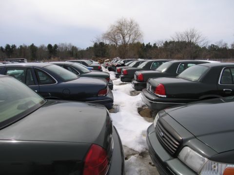 1991 Ford Crown Victoria LTD - A fleet of Ford Crown Victoria Police Interceptors are parked in a lot, suggesting a police auction or impound lot.