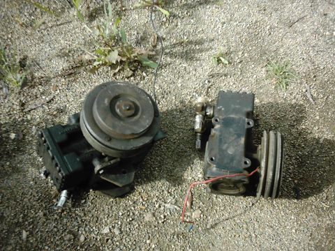 1978 Ford Bronco - Two automotive air conditioning compressors are shown resting on a gravel surface.