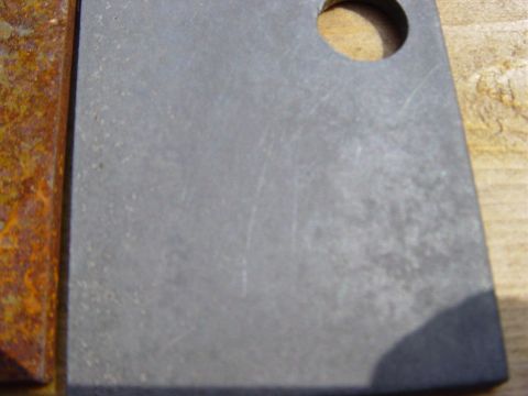 1988 Ford Bronco - A metal part shows signs of rust on its edge and a drilled hole, indicating wear or preparation for repair.