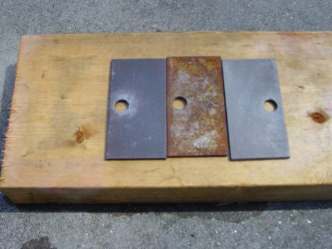 1988 Ford Bronco - Three metal plates, one showing rust, are laid out on a wooden plank with a visible website address.