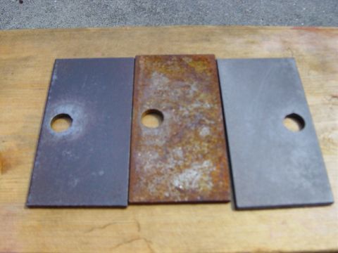 1988 Ford Bronco - Comparison of three metal plates, showing one in a rusted condition next to two clean ones.