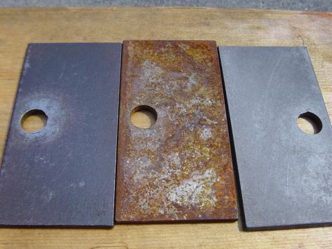 1988 Ford Bronco - Comparison of three metal plates, showing varying degrees of rust and surface finish.