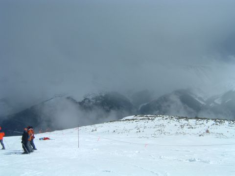 1992 Ford Probe - A snowy mountain scene with several skiers on a slope, with clouds obscuring the peaks.