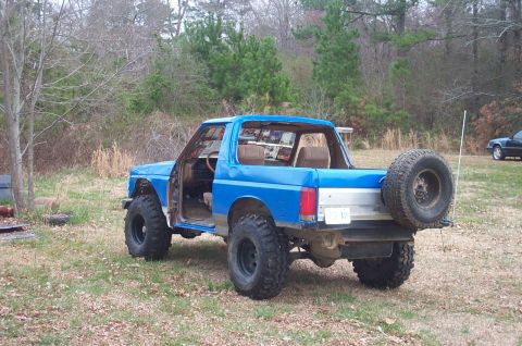 1987 Ford Bronco - This blue 1987 Ford Bronco is shown from the rear quarter angle, its spare tire mounted on the back.