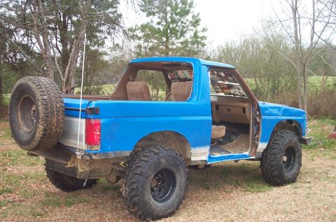 1987 Ford Bronco - This 1987 Ford Bronco features a bright blue paint job, lifted suspension, and is missing its doors.