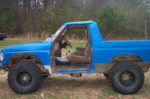1987 Ford Bronco - This blue SUV is missing its doors and appears to be undergoing some modifications or repairs.
