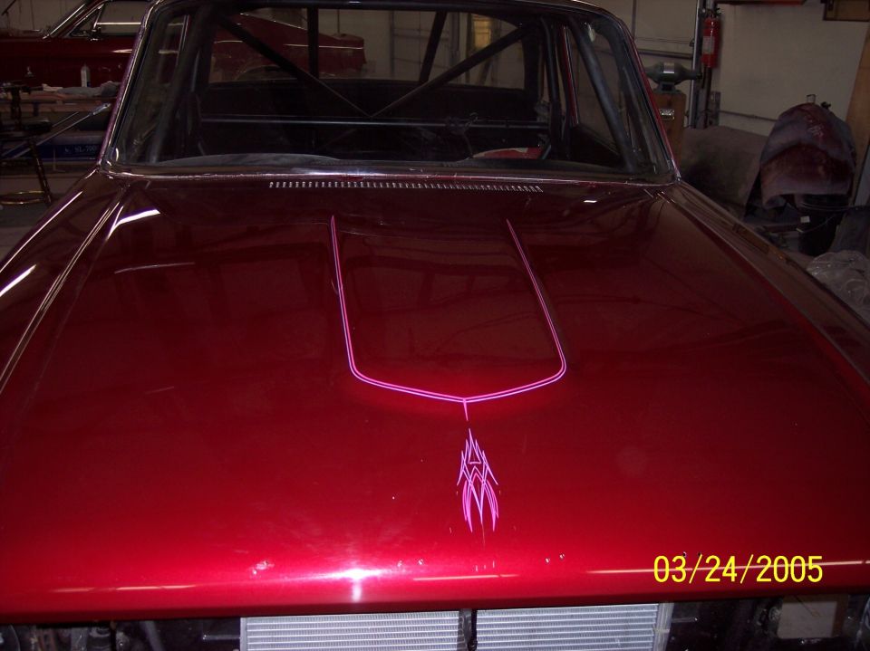 Candy red car hood with pink pinstriping, roll cage visible through windshield