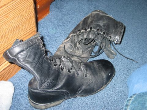 1995 Ford Bronco - A pair of well-worn black leather combat boots are shown on a blue carpeted floor.