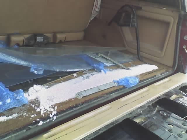 Interior cargo area of a vehicle with some white powder and blue plastic bags