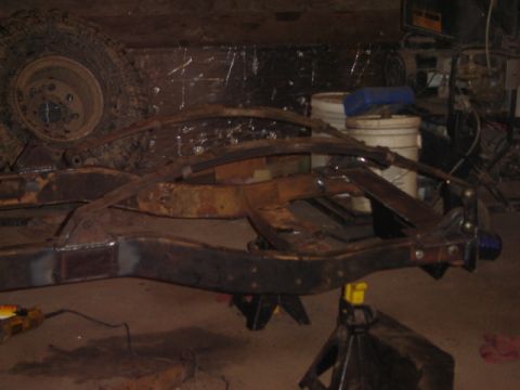 1992 Ford Bronco - Close-up of a vehicle's rusty frame and suspension components, possibly undergoing restoration.