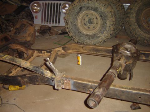1992 Ford Bronco - A Jeep CJ-6 frame is shown with large tires and a differential, suggesting a restoration or repair project.