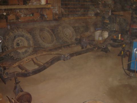 1992 Ford Bronco - Workshop scene showing a vehicle frame and spare tires.