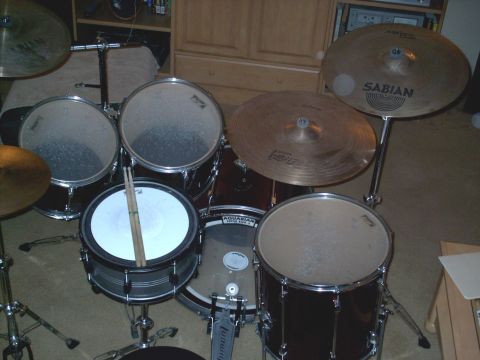 1986 Ford Bronco - A drum kit is set up indoors, with various drums and cymbals visible.