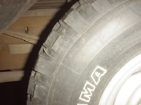 1989 Ford Bronco - Close-up of a damaged tire, showing cracks on the sidewall and tread blocks.