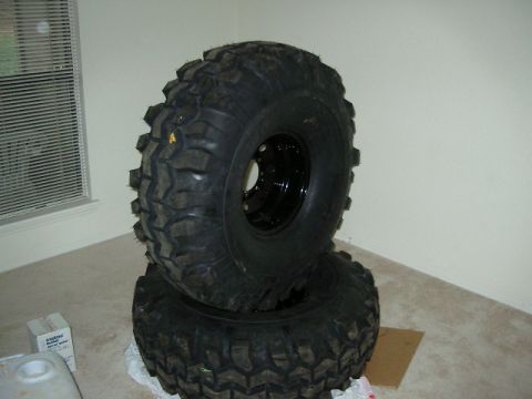 1985 Ford Bronco - Two large off-road tires are stacked on top of each other indoors.