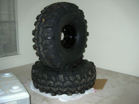 1985 Ford Bronco - Two large off-road tires are stacked on top of each other inside a room.