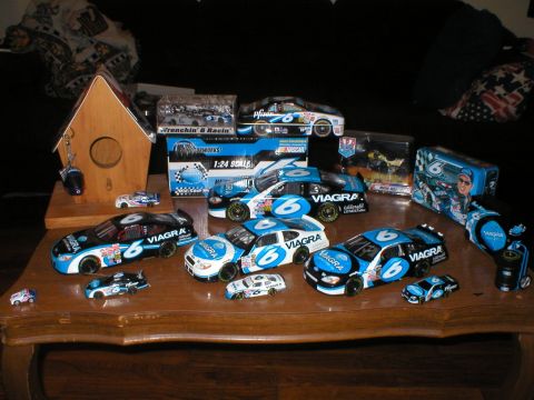 1987 Ford Crown Victoria LTD - Various NASCAR model cars, predominantly blue and black with Viagra sponsorship, are displayed on a wooden table.