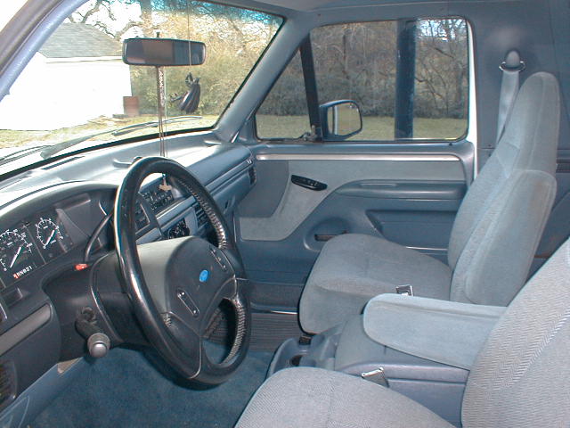 Interior of a Ford SUV showing steering wheel, gray cloth seats, and dashboard