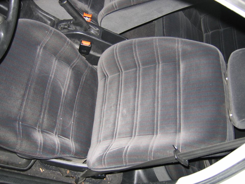 Front car seats with patterned fabric and seatbelts visible