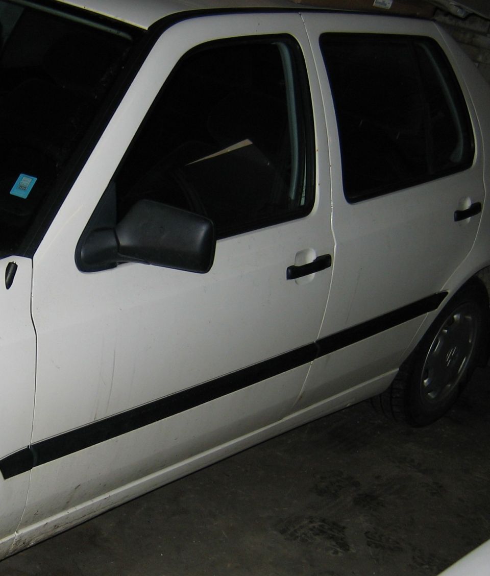 Side view of a white car showing the front door, rear door, and part of the rear wheel