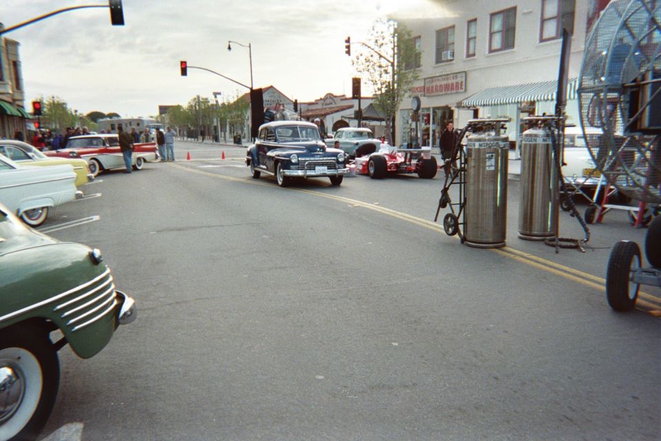 Downtown street with classic cars, a dark vintage coupe and gas cylinders on a dolly