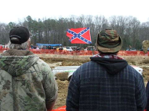 1996 Ford Bronco - Spectators observe a mud bog event with a confederate flag visible in the distance.