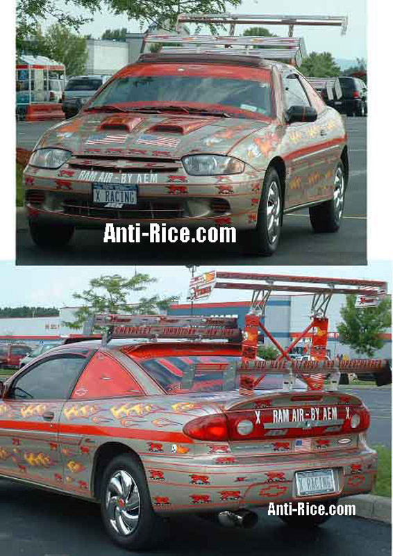 Modified Chevrolet Cavalier with large rear wing and flame decals. License plate reads 'X RACING'