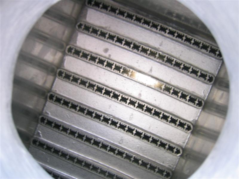 Close-up inside an aluminum intercooler core showing stacked multi-port flat tubes