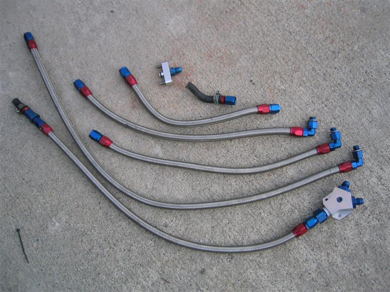 Braided stainless AN hoses with red and blue fittings and an aluminum distribution block