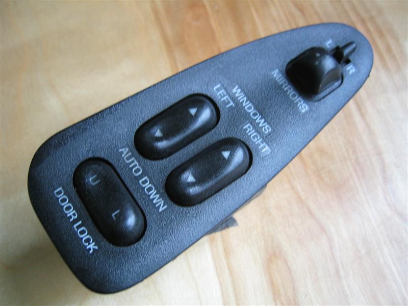 Black master door and window switch panel with MIRRORS toggle and AUTO DOWN lettering
