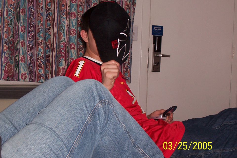 Person holding a phone in a hotel room with a "For Your Protection" sign on the door