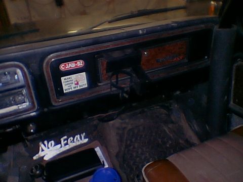1979 Ford Bronco - Dashboard interior with various stickers and text visible on the floor mat.