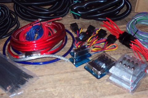 1985 Ford LTD Crown Victoria - Various automotive wiring components and cables are laid out on a wooden surface.