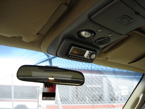 1995 Ford Bronco - Angled interior shot of a truck's tan headliner and gray overhead console, with map lights, switches and an aftermarket satellite-radio hea…