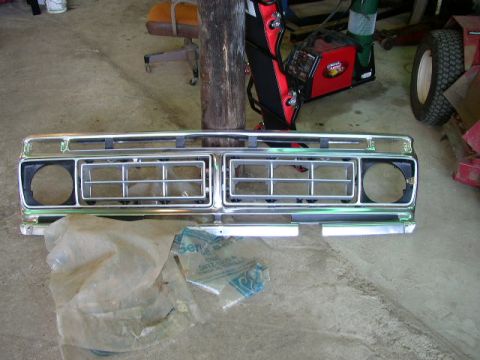 1995 Ford Bronco - A chrome grille, likely for a truck or SUV, is shown lying on a concrete floor.