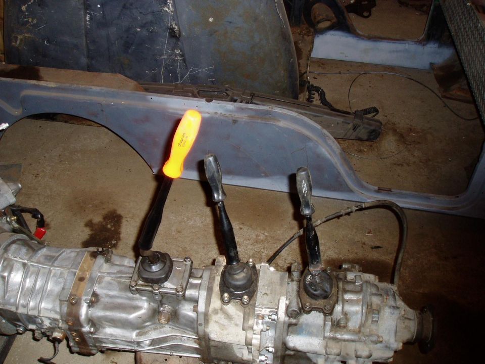 Transmission with three shifters and a yellow-handled screwdriver