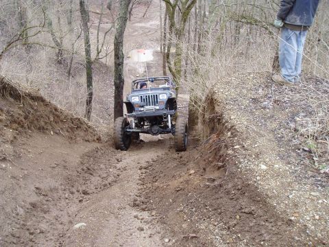 1992 Ford Bronco - A modified Jeep Wrangler navigates a challenging, muddy off-road course.