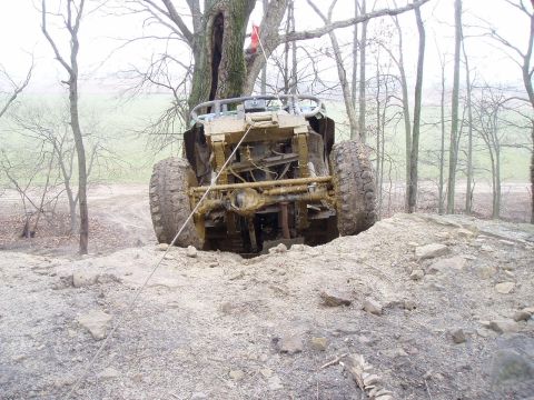 1992 Ford Bronco - An off-road vehicle is stuck in the dirt, viewed from the rear, with a Supermotors.net logo in the corner.