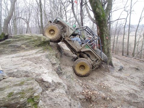 1992 Ford Bronco - This heavily modified off-road vehicle navigates a challenging rocky terrain with a driver and passenger visible.