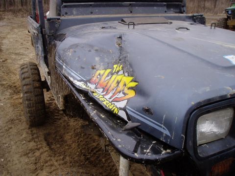 1992 Ford Bronco - This Jeep Wrangler has significant damage to its front fender and hood, with a sticker on the hood.