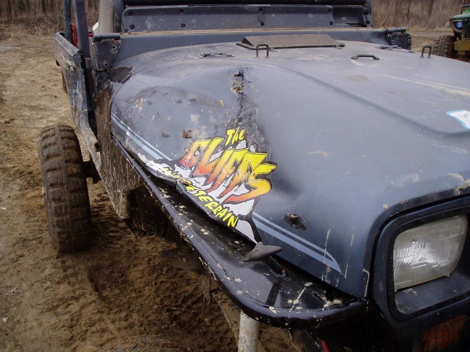 Damaged Jeep Wrangler hood with 'The Elite' sticker. Another Jeep is visible in the background
