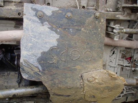 1992 Ford Bronco - Close-up of a muddy undercarriage component showing embossed text that appears to read '3dcoo'.